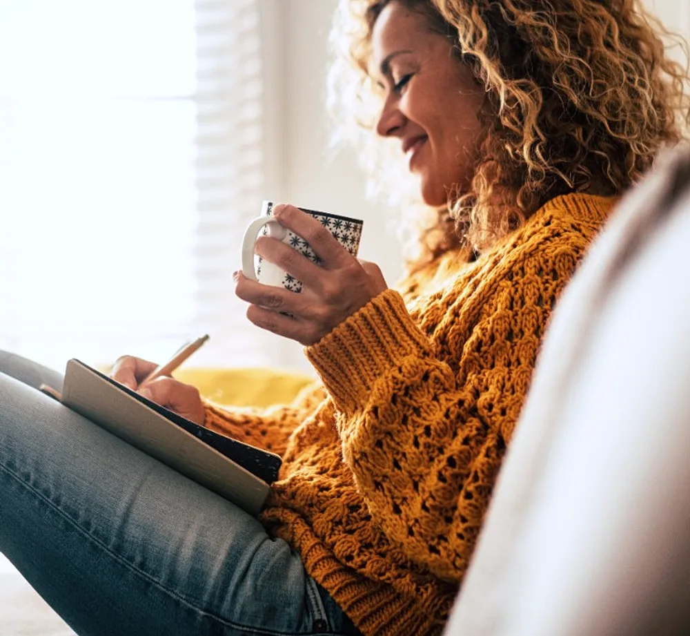 Frau mit Tasse und Notizbuch – Orientierung für den nächsten Schritt